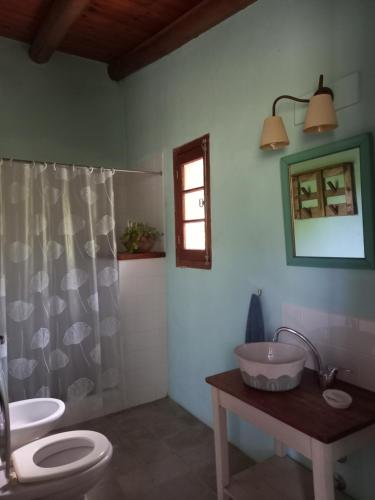 a bathroom with two sinks and a toilet and a window at Casa.Colibri.LaCumbre in La Cumbre