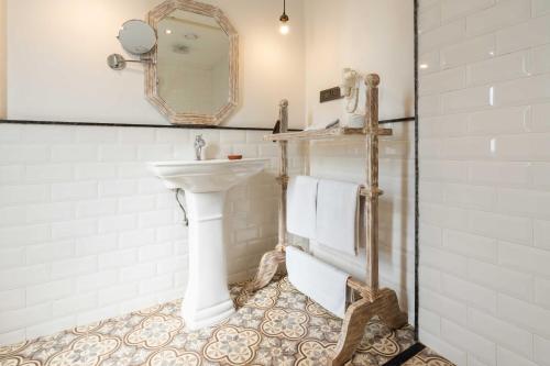 a white bathroom with a sink and a mirror at Seto Ghar Hotel in Kathmandu