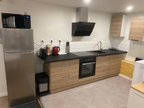 eine Küche mit einem Kühlschrank aus Edelstahl und einer Mikrowelle in der Unterkunft Coeur de Jaude 2 chambres Tout équipé 4 personnes in Clermont-Ferrand