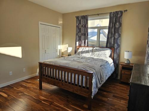 1 dormitorio con cama de madera y ventana en THURBER HOUSE en Duncan