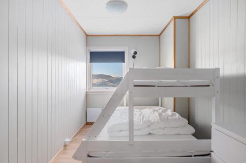 Litera blanca en habitación con ventana en Voss Resort Bavallstunet en Skulestadmo