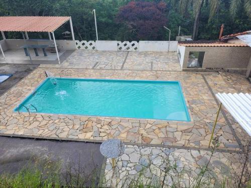 una piscina en un patio con un patio de piedra en Sítio Elo Perdido Guararema en Guararema