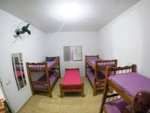 um quarto com três camas e uma mesa e cadeiras em Sítio Elo Perdido Guararema em Guararema