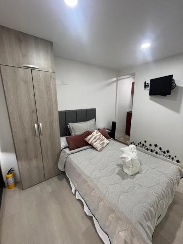 een slaapkamer met een groot bed en een kast bij Cozy self-contained studio in Medellín