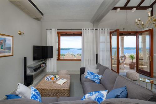a living room with a couch and a tv at Luxury Villa Hvar Carpe Diem with private pool by the sea in Hvar