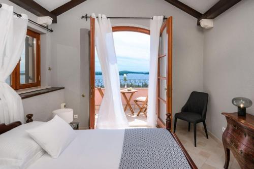 a bedroom with a bed and a view of the ocean at Luxury Villa Hvar Carpe Diem with private pool by the sea in Hvar