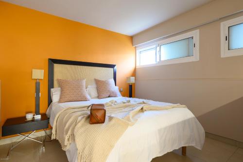Un dormitorio con una cama grande y dos ventanas. en Villa Atlantis - San Agustín, en San Agustín