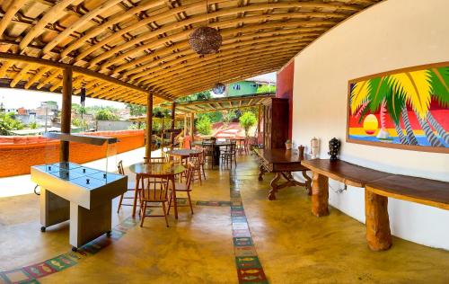 a restaurant with tables and chairs in a room at Pousada Pedra Alta in Itacaré