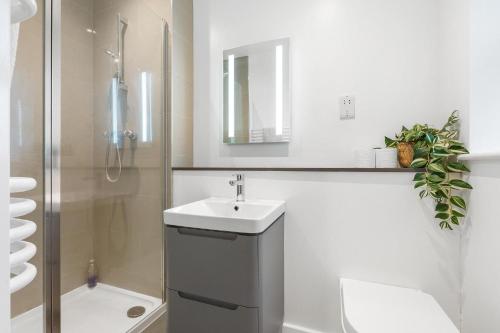 ロンドンにあるSpacious Clapham Apartmentsの白いバスルーム(シンク、シャワー付)