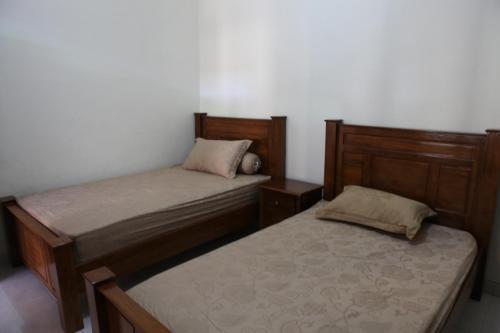 two beds sitting next to each other in a bedroom at Griya Hanna in Yogyakarta