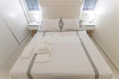 een bed in een kamer met 2 ramen bij Exceptional Apartment W Great Amenities in Asuncion