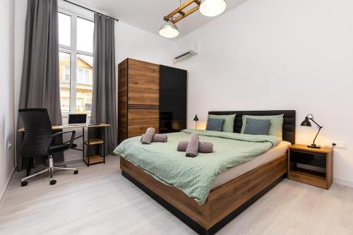 um quarto com uma cama e uma secretária com um computador em Kapana Beat 2-bedroom apt. Top Center em Plovdiv