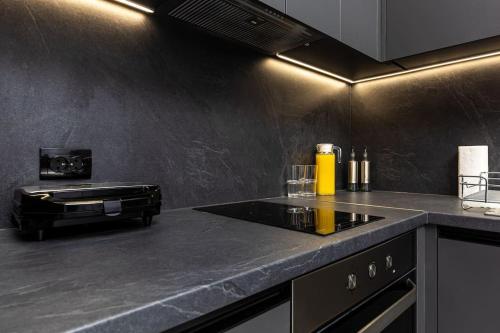a kitchen with a black counter top with a stove at Kapana Beat 2-bedroom apt. Top Center in Plovdiv