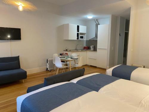 1 dormitorio con 2 camas, mesa y cocina en Mouzinho 244 - Porto Houses & Suites, en Oporto