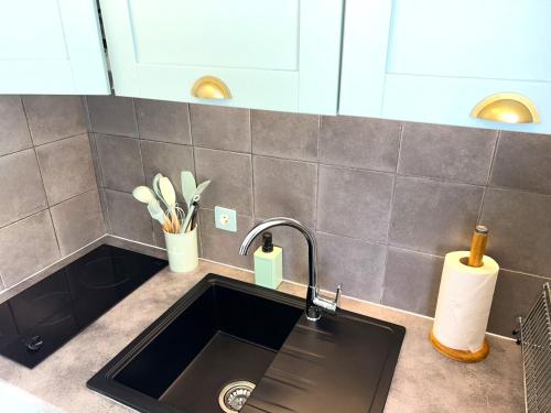 a kitchen sink with a faucet on a counter at STUDIO POOL HOUSE MDT 2 ETOILES VUE MER PANORAMIQUE AMAZING SEA VIEW WIFI LINGE LINEN INCLUT AIRCONDITIOn in La Croix-Valmer