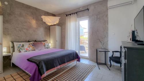 ein Schlafzimmer mit einem lila Bett und einem Fenster in der Unterkunft Arte no5 in Novigrad Istria