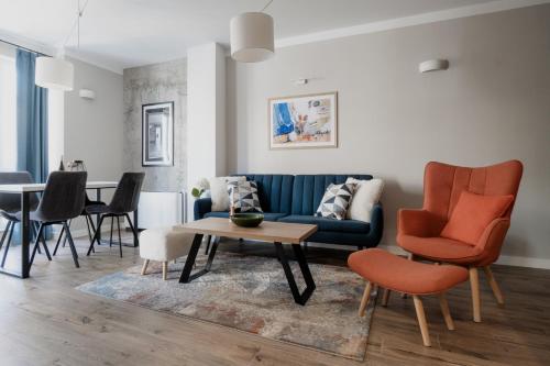 uma sala de estar com um sofá azul e cadeiras em 8th Hill em Plovdiv