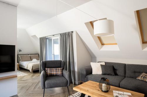 a living room with a couch and a chair at 8th Hill Apartments in Plovdiv