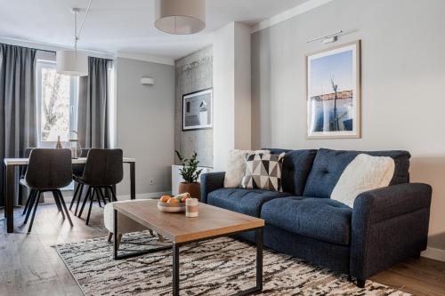 a living room with a blue couch and a table at 8th Hill Apartments in Plovdiv