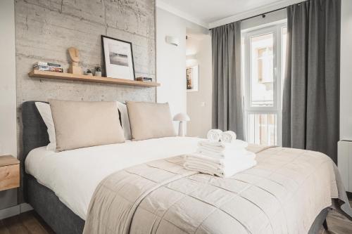 a bedroom with a white bed and a brick wall at 8th Hill Apartments in Plovdiv