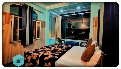 a bedroom with a bed and a window with a view at Shri Ganga View Guest House in Rishīkesh