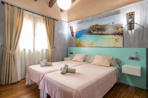 une chambre avec deux lits et un tableau au mur dans l'établissement Sa Teulada, à Santa Margalida