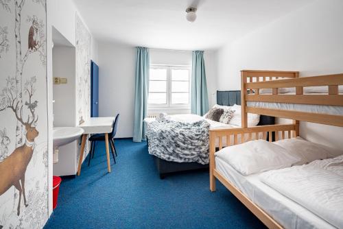 a bedroom with two bunk beds and a sink at Prazska Bouda in Pec pod Sněžkou