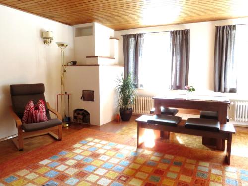 a living room with a piano and a chair at Ferienwohnung Aumühle in Freilassing