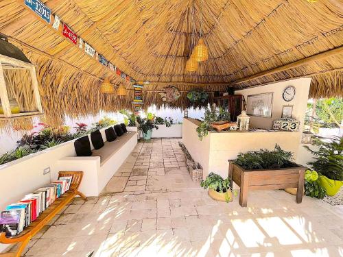 um restaurante com um telhado de palha e uma área de estar em Aruba Lagunita em Palm-Eagle Beach