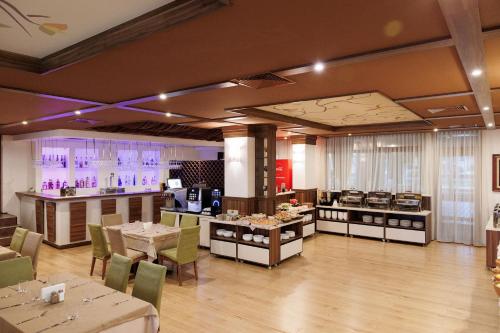 a restaurant with tables and chairs and a kitchen at Green Wood Hotel & Spa in Bansko