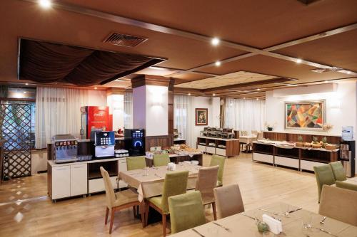 a restaurant with tables and chairs and a buffet at Green Wood Hotel & Spa Bansko in Bansko