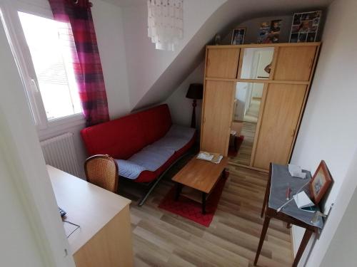 a living room with a red couch and a table at PAVILLON PROCHE RER et DisneyLand in Gagny