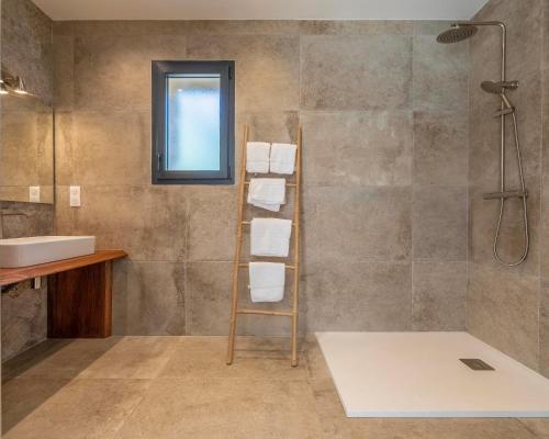 une salle de bain avec un lavabo et une douche dans l'établissement Les Bergeries du Domaine de Pinelli, à Belgodère