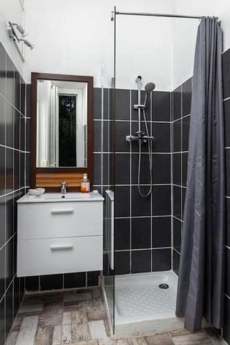 une salle de bain avec un lavabo blanc et une douche dans l'établissement L'Aix Capade Zen, à Aix-les-Bains