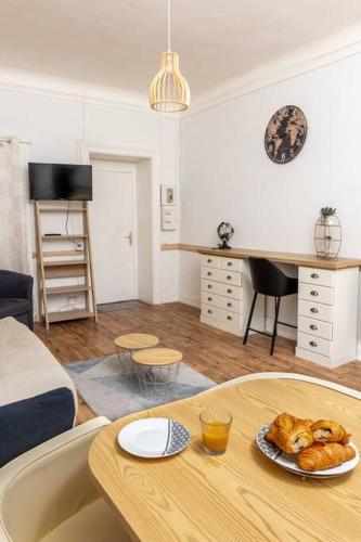 - un salon avec une table et une assiette de pain dans l'établissement L'Aix Capade Zen, à Aix-les-Bains