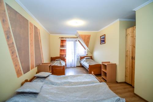a bedroom with two beds and a window at Cudzichówka in Biały Dunajec