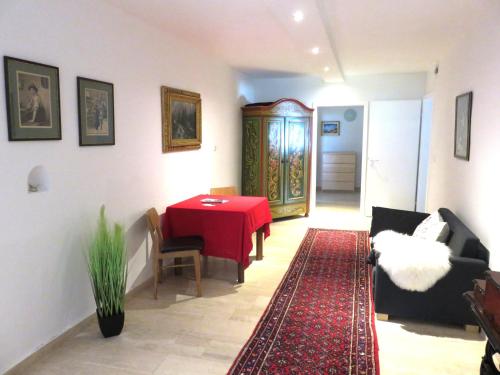 a living room with a red table and a red rug at Ferienwohnung Aumühle in Freilassing