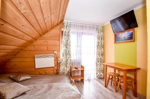 a room with a bed and a desk and a window at Cudzichówka in Biały Dunajec