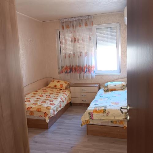 um pequeno quarto com 2 camas e uma janela em Апартамент МИА em Plovdiv