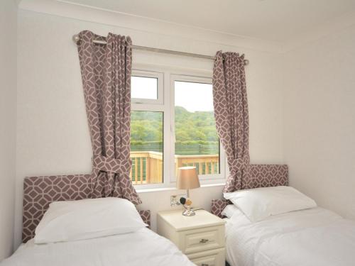 two beds in a room with a window at 2 Bed in Okehampton 74242 in Okehampton