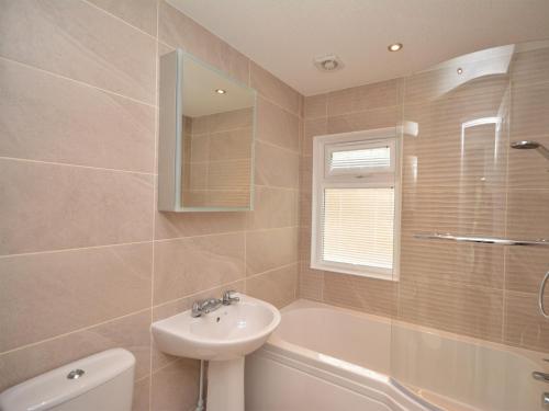a bathroom with a sink and a toilet and a tub at 2 Bed in Okehampton 74242 in Okehampton