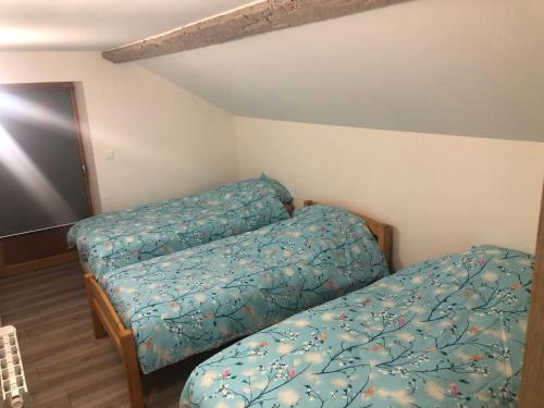 2 Betten in einem kleinen Zimmer mit Bettröcken in der Unterkunft Gîte La Baronnière in Vouzon