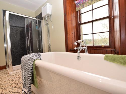 a bath tub in a bathroom with a window at 5 bed in Chirnside 77337 in Duns