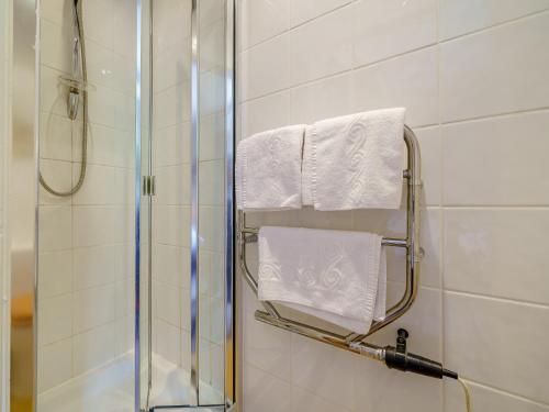 a bathroom with a shower and white towels at 3 Bed in Crosthwaite 75564 in Crosthwaite