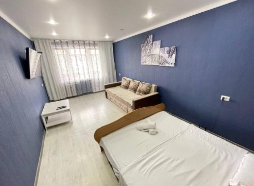 1 dormitorio con 2 camas y pared azul en Сокол en Petropavlovsk