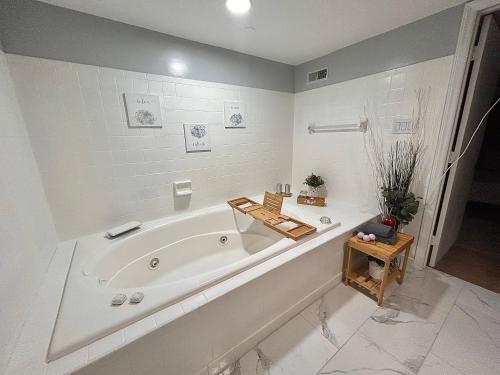 a white bathroom with a tub in a room at Comfy Lower Lvl Apt with Jetted Tub Near Uptown and UNC in Charlotte