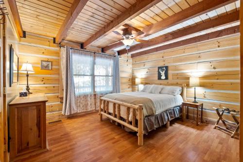 um quarto com uma cama num chalé de madeira em Antlers Crossing em McGaheysville