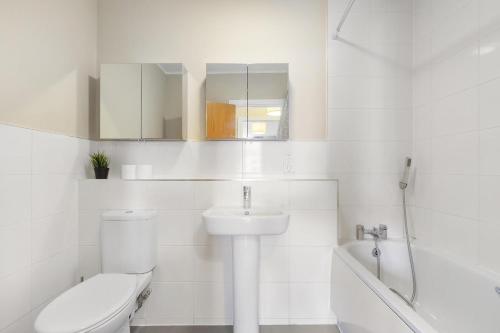 a white bathroom with a toilet and a sink at 221 Clapham Road Apartments in London