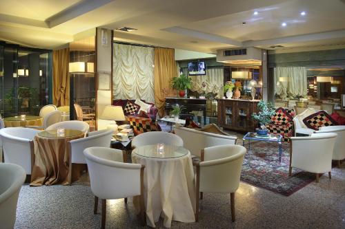 a restaurant with tables and chairs and a lobby at Hotel Nuovo Savi in Montecatini Terme