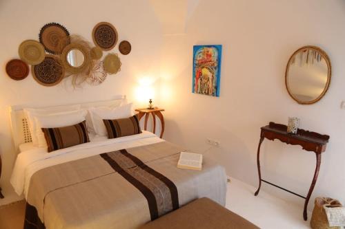 a bedroom with a bed and mirrors on the wall at Dar AZUR HAMMAMET FORT in Hammamet